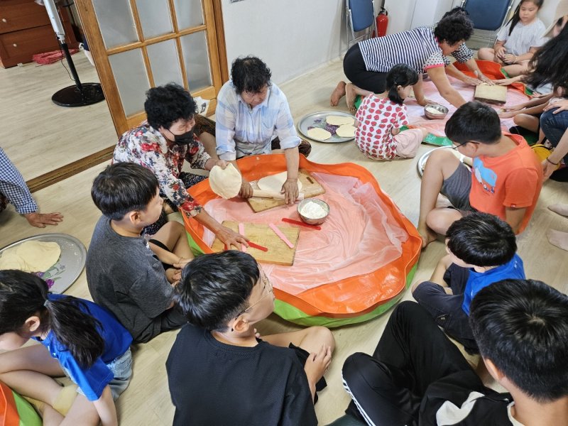 영암 학산초등학교(교장 정공순)- 학생들이 지난달 26일 학교 인근 천해마을 마을회관에서 마을 어르신들과 함께 팥칼국수 만들기 체험을 하고 있다.(전남교육청 제공)/뉴스1