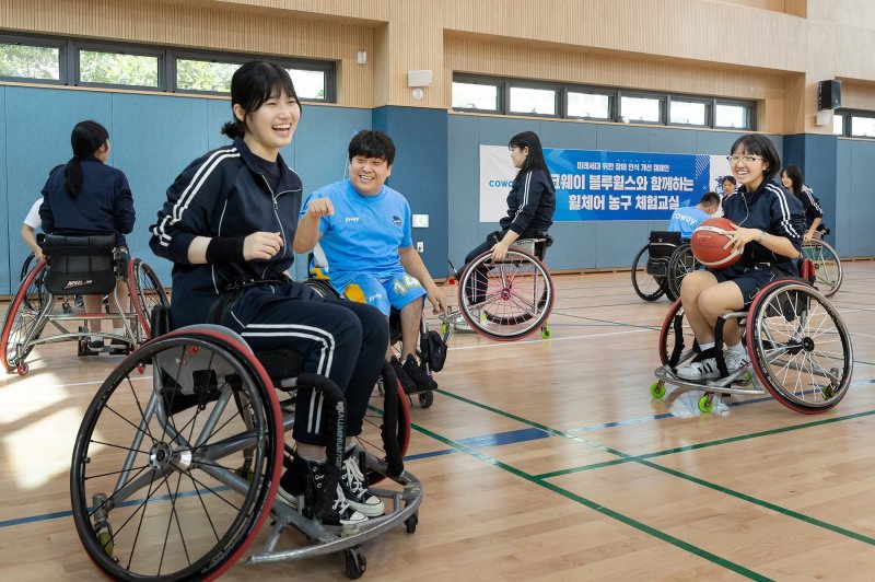 코웨이 블루휠스 휠체어농구단 선수들이 지난 8월 30일 서울 관악구 영락고에서 진행한 장애 인식 개선 캠페인에서 영락고 학생들과 함께 운동하고 있다. 코웨이 제공