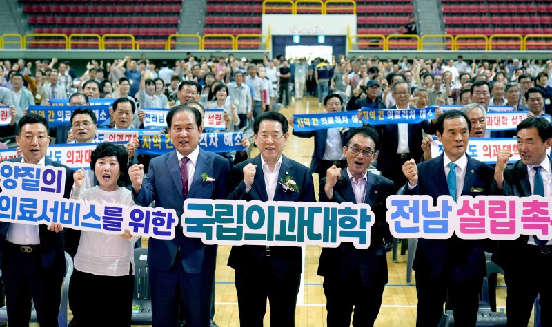 [진도=뉴시스] 이창우 기자=김영록 전남도지사(가운데)가 17일 진도군실내체육관에서 열린 '2023 전남 새농민회 한마음 전진대회'에서 참석자들과 전남도 국립의대 설립을 촉구하는 퍼포먼스를 하고 있다. (사진=전남도 제공) 2023.08.17. photo@newsis.com