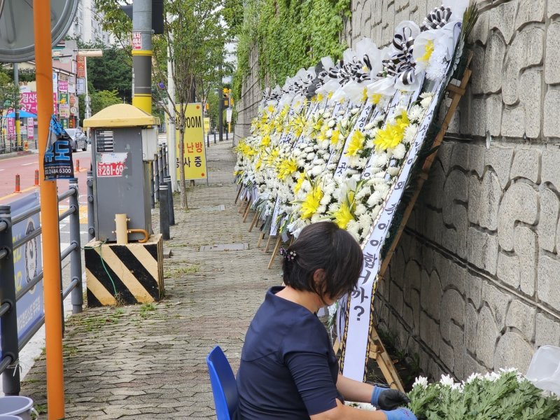 극단적인 선택을 한 60대 체육교사가 재직했던 경기 용인시의 한 고등학교 정문 앞에 마련된 추모공간.전국의 동료교사들과 제자들이 화환과 메모로 고인의 죽음을 애도하고 있다. ⓒ News1 김평석 기자