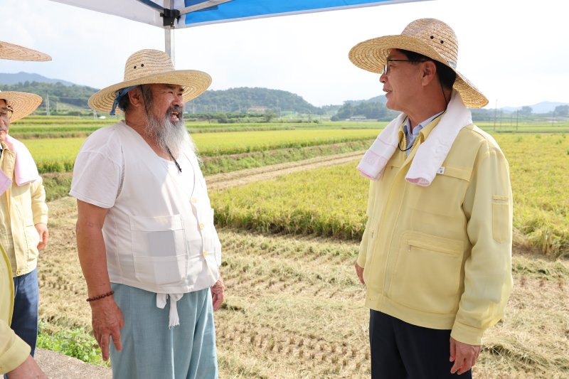 심덕섭 전북 고창군수(오른쪽)가 벼 재배 현장을 찾아 농민과 대화하는 모습. 고창군 제공