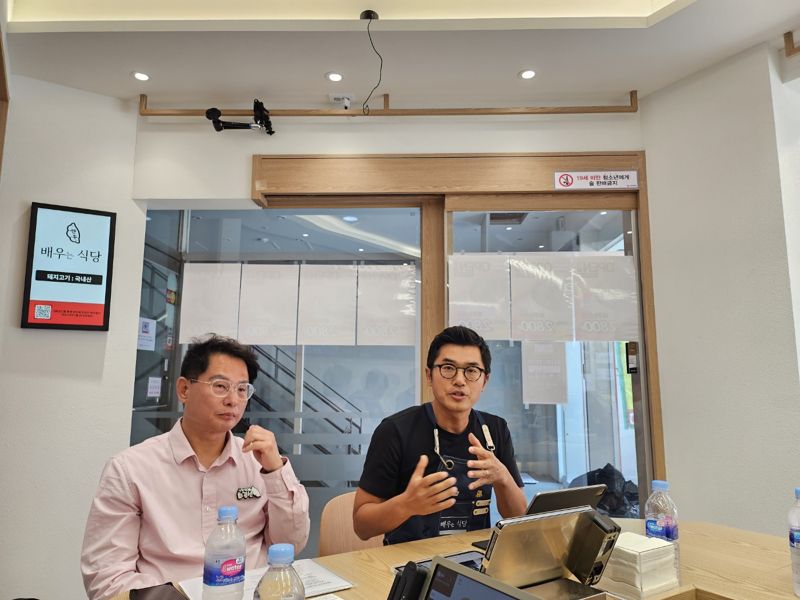 김현민 LG유플러스 상무(오른쪽)와 최경선 더본코리아 전무가 서울 강남구 '식당연구소' 1호점에서 기자들의 질문에 답하고 있다. 사진=김준혁 기자