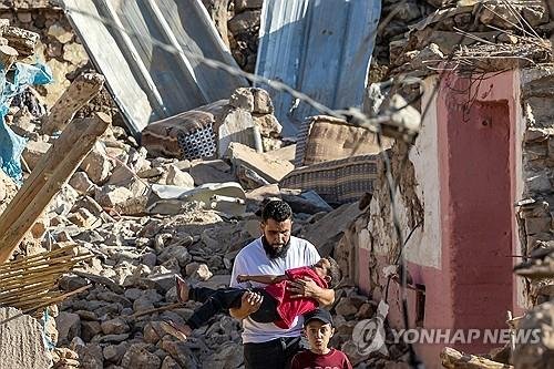 무너진 건물 잔해에서 한 소년을 구해 나오는 모로코 남성./사진=연합뉴스