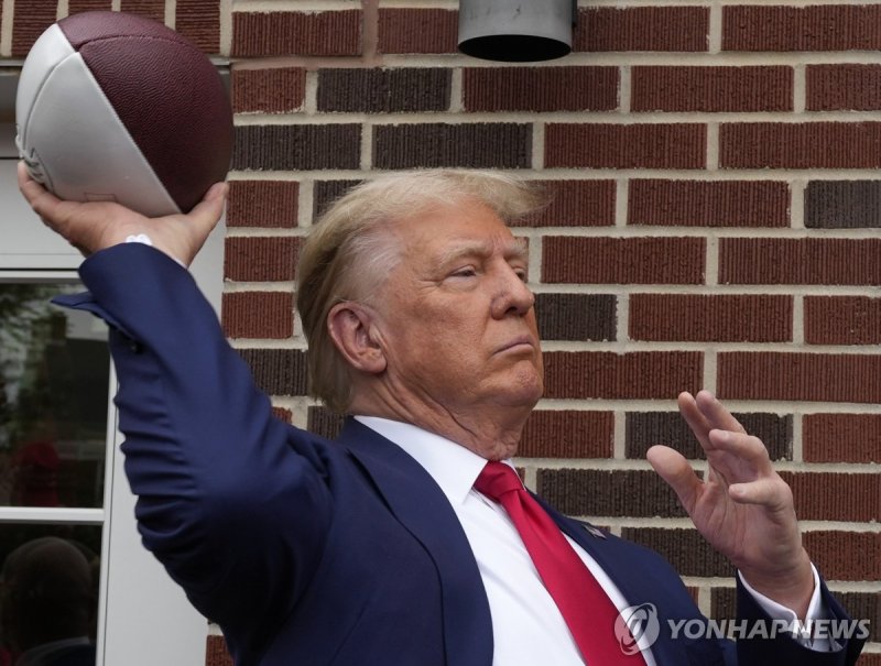 도널드 트럼프 전 미국 대통령 Former President Donald Trump throws a football to the crowd during a visit to the Alpha Gamma Rho, agricultural fraternity, at Iowa State University before an NCAA college football game between Iowa State and Iowa, Saturday, Sept. 9, 2023, in Ames, Iowa. (AP Photo/Charlie Neibergal