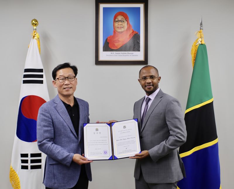 11일 오전 주한 탄자니아대사관에서 진행된 글로벌 캠페인 '우리 지구, 함께 입어요' 성료에 따른 감사장 전달식에서 임대규 현대홈쇼핑 사장(왼쪽)이 토골라니 에드리스 마부라 주한 탄자니아 대사로부터 감사장을 받고 기념촬영을 하고 있다./ 사진=현대홈쇼핑