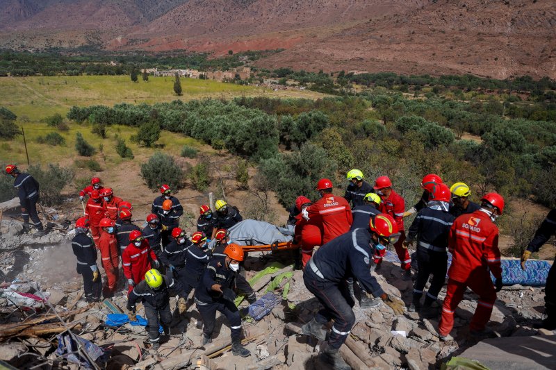 12일(현지시간) 모로코 탈낫 냐콥에서 구조대원들이 지진 사망자의 시신을 옮기고 있다.로이터뉴스1