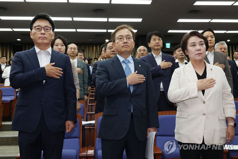 박광온 더불어민주당 원내대표 등 지도부가 14일 국회에서 열린 의원총회에서 국기에 대한 경례를 하고 있다. 연합뉴스