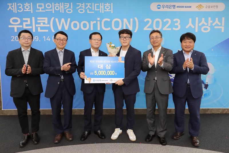 우리은행은 지난 14일 서울 중구 우리은행 본점에서 제3회 모의해킹 경진대회 '우리콘(WooriCON) 시상식을 개최했다. 고려대 김휘강 교수, 박춘식 아주대학교 교수, 조병규 우리은행장, 대상 수상자, 김철웅 금융보안원장, 김백수 우리은행 정보보호그룹 부행장(왼쪽부터)가 기념촬영을 하고 있다. 우리은행 제공.