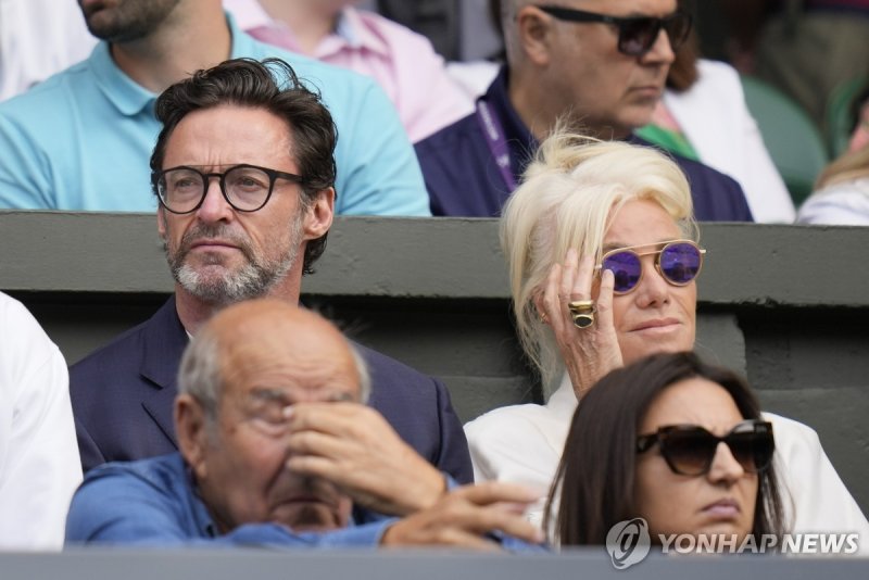 지난 7월 윔블던 테니스 경기를 관람하는 휴 잭맨과 부인 데버러 리 퍼니스 Actor Hugh Jackman, left, sits in the stands on Centre Court for the final of the men's singles between Spain's Carlos Alcaraz and Serbia's Novak Djokovic on day fourteen of the Wimbledon tennis championships in London, Sunday, July 16, 2023. (AP Photo/Kirst