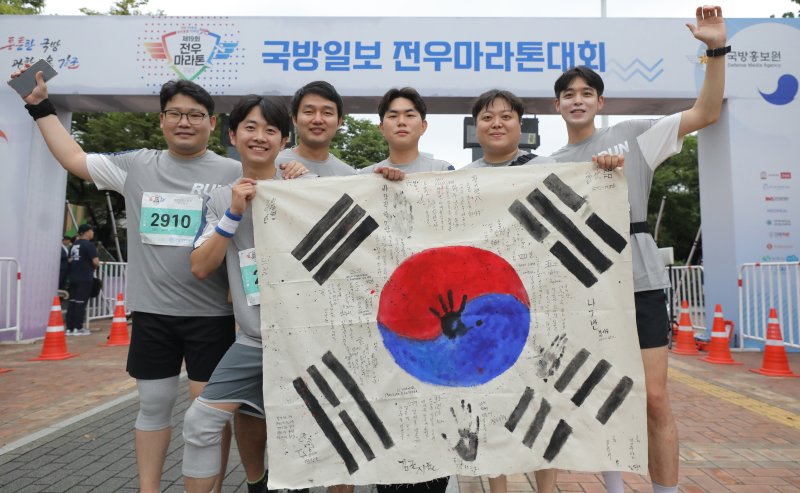 [서울=뉴시스] 김금보 기자 = 16일 오전 서울 송파구 올림픽공원 평화의광장 일대에서 열린 '건군 75주년 및 한미동맹 70주년 기념 제19회 국방일보 전우마라톤'에서 경기모바일고학고등학교 교사와 참가자들이 직접 제작한 태극기를 들고 기념촬영을 하고 있다. 2023.09.16. kgb@newsis.com