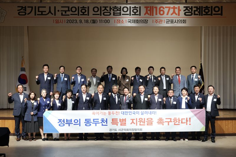 18일 군포문화예술회관에서 열린 제167차 경기도시군의회의장협의회에 참여한 31개 시군의회 의장들이 동두천의 특별지원을 촉구하는 현수막을 들고 사진 촬영을 하고 있다. /동두천시의회 제공