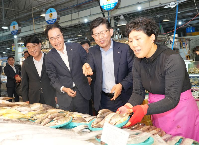 빈대인 BNK금융그룹 회장(오른쪽)과 예경탁 경남은행장(가운데), 방성빈 부산은행장이 19일 울산농수산물도매시장에서 수산물을 구입하고 있다. BNK경남은행 제공