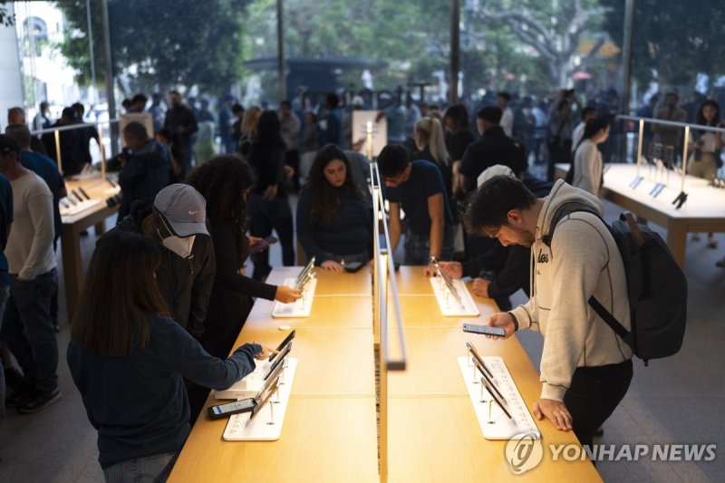 LA 애플 매장에서 아이폰15를 체험하는 사람들 People look at the Apple's new iPhone 15 models on the first day of sales at an Apple Store at The Grove in Los Angeles, Friday, Sept. 22, 2023. (AP Photo/Jae C. Hong)