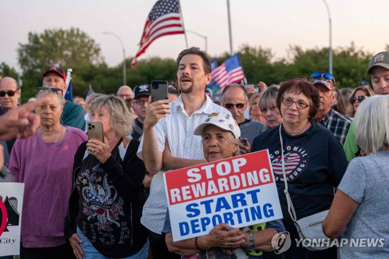 뉴욕의 망명 신청자 숙소 예정지 앞에서 열린 지역주민들의 반대 시위 NEW YORK, NEW YORK - SEPTEMBER 14: Residents attend a rally against the housing of migrants at Floyd Bennett Field in Brooklyn on September 14, 2023 in New York City. Dozens of people attended the evening rally where various speakers denounced both city leaders 