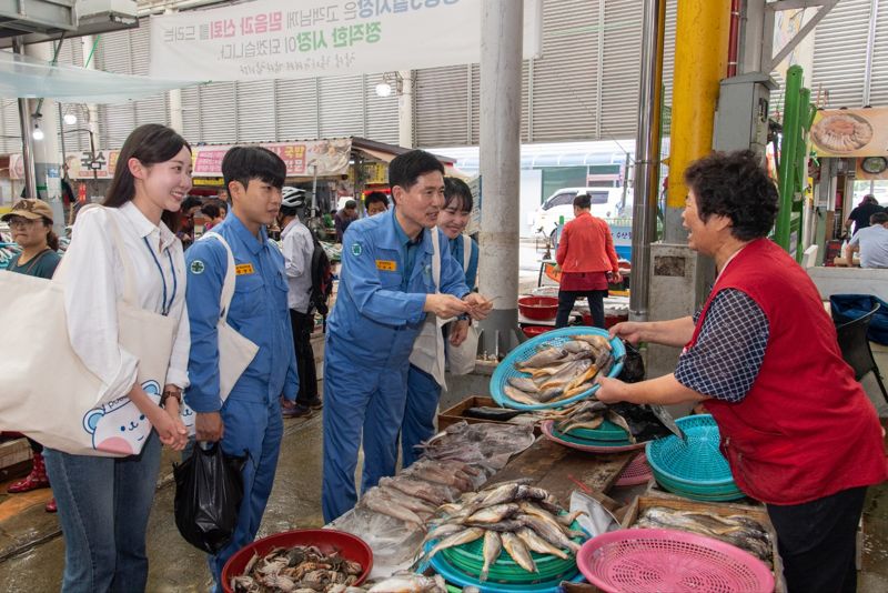 광양제철소가 26일 광양시·광양상공회의소·광양경제활성화본부와 광양 5일시장을 방문해 지역 농·수산물 소비 촉진과 함께 지역 경제 활성화에 나선 가운데 이철호 광양제철소 부소장이 직원들과 함께 수산물을 구매하고 있다. 광양제철소 제공