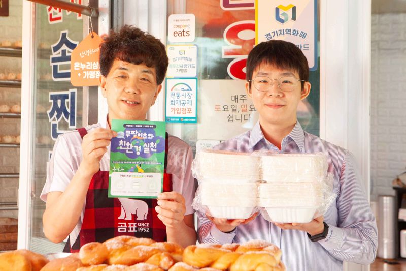 박강석 천지만나 대표(왼쪽)와 쿠팡이츠서비스 담당자가 쿠팡이츠 친환경 포장 용기를 들고 사진을 촬영하고 있다. 쿠팡이츠 제공.