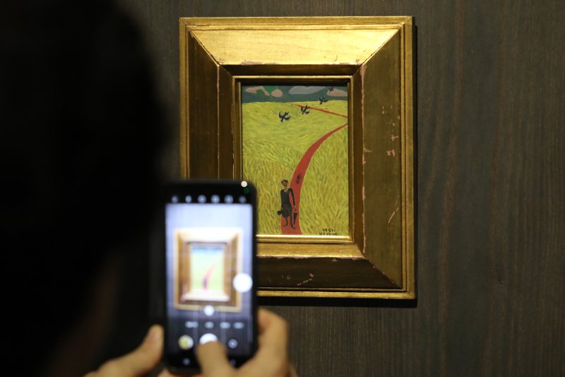 [서울=뉴시스] 박진희 기자 = '자화상'(1951) 작품. 6.25전쟁 이후 임시수도인 부산에서 피난살이를 하던 장욱진이 종군화가로 복무 중에 잠시 고향인 충남 연기군(지금의 세종시)에서 머물던 시기 그린 작품이다. 그는 이 시기 방황에서 잠시 안정을 찾으니 작품 의욕이 솟아 “미친 듯이 그리고 또 그렸다”고 전한다. 한 뼘 크기의 작은 종이 위에 유화 물감으로 그려진 '자화상'은 누렇게 황금 물결을 이룬 벼 이삭과 기찻길처럼 하염없이 펼쳐진 붉은 황토색의 논두렁 사이로 콧수염을 기른 모던한 모습의 장욱진이 걸어오고 있다. 결혼식