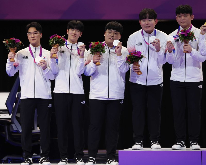 [항저우=뉴시스] 조수정 기자 = 1일 중국 항저우 이스포츠센터에서 열린 2022 항저우 아시안게임 E스포츠 '배틀그라운드 모바일(아시안게임버전)' 결승전, 은메달을 획득한 한국팀 '스포르타' 김성현, '씨재' 최영재, '파비안' 박상철, '비니' 권순빈,'티지' 김동현이 시상식대에 올라 메달을 들어 보이고 있다. 2023.10.01. chocrystal@newsis.com