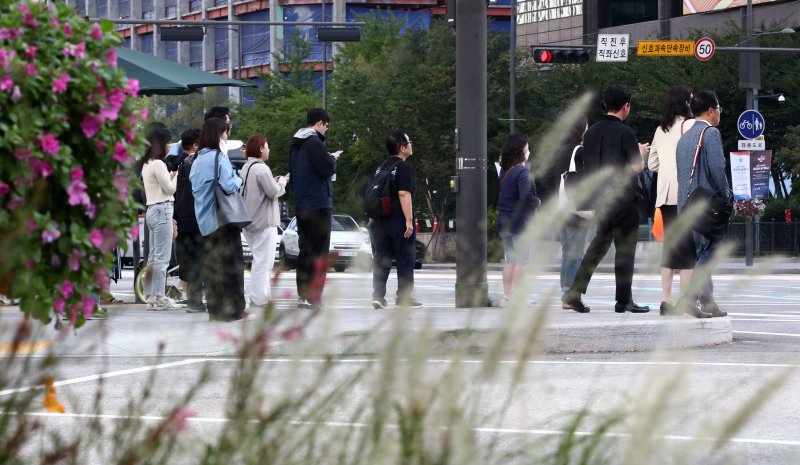 서울 최저기온이 16도까지 떨어지며 선선한 가을날씨를 보인 22일 오전 서울 세종대로사거리에서 긴팔과 외투를 입은 출근길 시민들이 발걸음을 재촉하고 있다. 기상청은 주말까지 일교차가 크고 맑은 전형적인 가을 날씨를 보이겠다고 밝혔다. 뉴스1