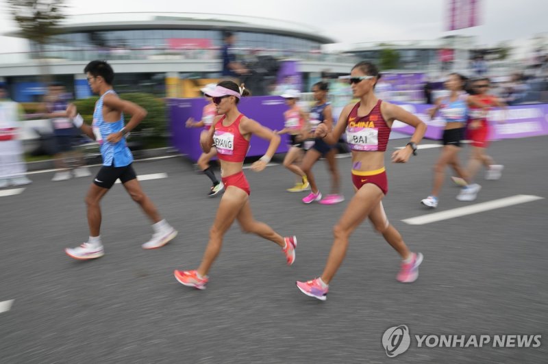 아시안게임에서 처음 열린 혼성 경보 China's Bai Xueying, right, and compatriot Qieyang Shijie compete during the mixed teams 35-kilometer race walk at the 19th Asian Games in Hangzhou, China, Wednesday, Oct. 4, 2023. (AP Photo/Lee Jin-man)