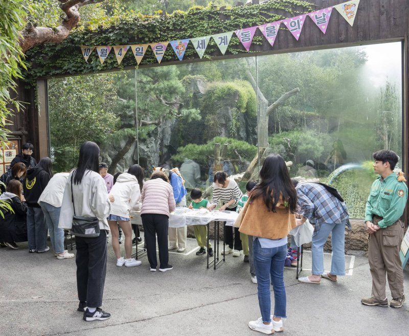 4일 에버랜드 동물원 타이거밸리를 찾은 고객들이 '세계 동물의 날' 종보전 캠페인에 참여해 호랑이 가면을 만들고 있다. 에버랜드 제공