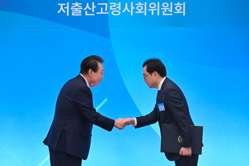 윤석열 대통령이 청와대 영빈관에서 열린 제1차 저출산고령사회위원회 회의에서 홍석철 상임위원에게 임명장을 수여한 후 악수하고 있다. (대통령실 제공) 2023.3.28/뉴스1 ⓒ News1 오대일 기자