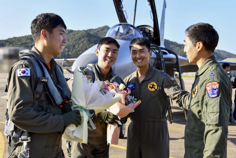 공군은 지난 5일 FA-50 전투기 통산 10만 시간 무사고 비행기록을 달성했다고 6일 밝혔다. 사진은 공군 제9전투비행단 김남영 소령(왼쪽 두 번째)과 박상원 대위(왼쪽 첫 번째)는 FA-50 10만 시간을 달성하는 비행을 마치고 부대원들로부터 꽃다발을 받는 모습. 사진=공군 제공