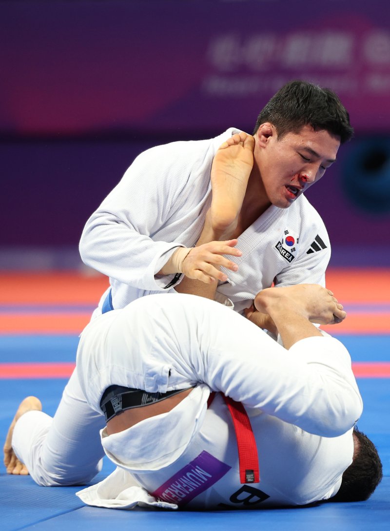 6일 중국 항저우 샤오산 린푸 체육관에서 열린 항저우 아시안게임 주짓수 남자 77kg급 결승 경기에서 한국 구본철이 바레인 압둘라 문파레디와 기술을 겨루고 있다.<div id='ad_body2' class='ad_center'></div>/사진=연합뉴스