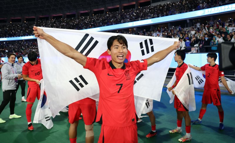 정우영 '금메달이다!' (항저우=연합뉴스) 2022 항저우 아시안게임 남자축구 결승전에서 일본을 2-1로 이기고 금메달을 획득한 한국의 정우영이 태극기를 펼치고 있다