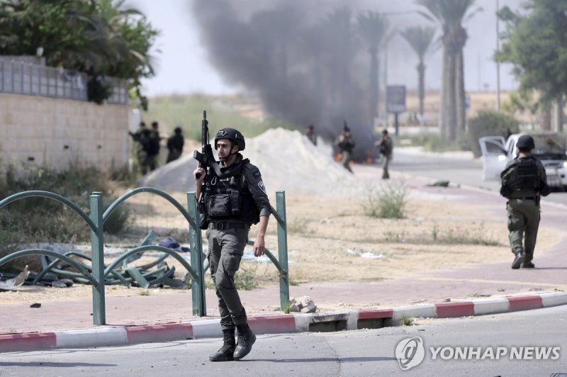 하마스 공격받은 남부지역 경비하는 이스라엘군 Israeli soldiers take position at the southern Israeli town of Ofakim on Sunday, Oct.8, 2023. Hamas militants stormed over the border fence Saturday, killing hundreds of Israelis in surrounding communities. The burning car was used by the gunmen and set on fire by the reside