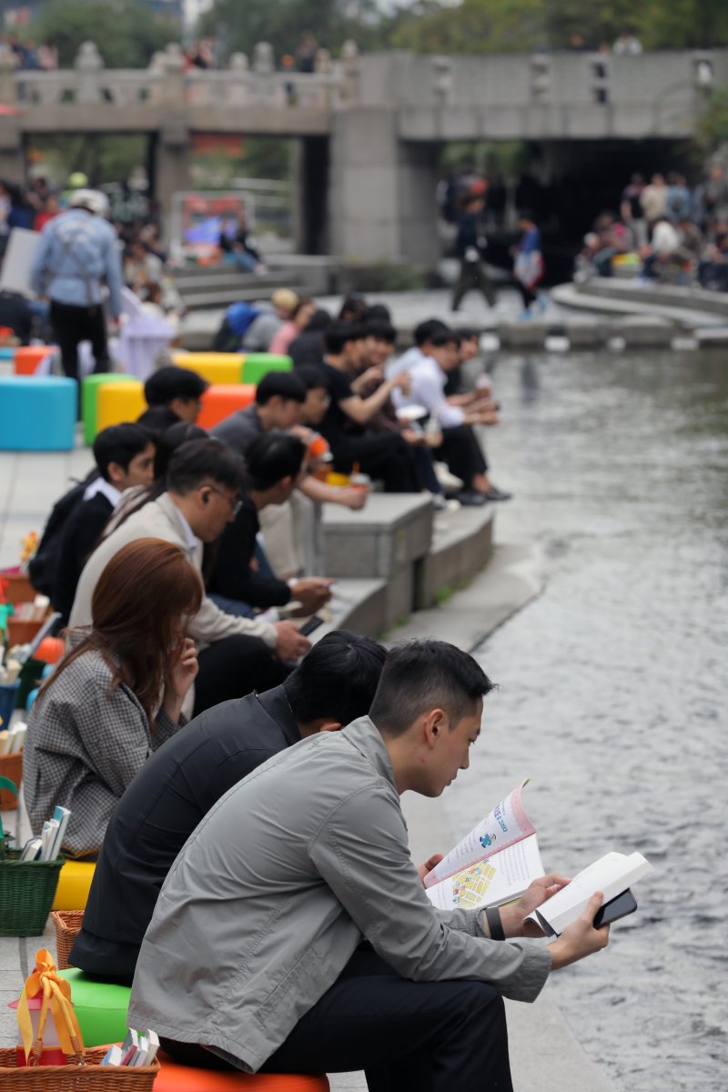 [서울=뉴시스] 김금보 기자 = 13일 서울 중구 청계천에 마련된 '책읽는 맑은냇가' 서울야외도서관을 찾은 시민들이 독서하며 휴식하고 있다. 서울도서관은 오는 15일까지 청계천 청계광장~모전교~광통교 구간에 책바구니를 비치하고 독서 구역으로 구성해 야외도서관으로 운영한다. 2023.10.13. kgb@newsis.com