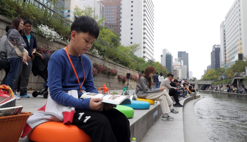 [서울=뉴시스] 김금보 기자 = 13일 서울 중구 청계천에 마련된 '책읽는 맑은냇가' 서울야외도서관을 찾은 시민들이 독서하며 휴식하고 있다. 서울도서관은 오는 15일까지 청계천 청계광장~모전교~광통교 구간에 책바구니를 비치하고 독서 구역으로 구성해 야외도서관으로 운영한다. 2023.10.13. kgb@newsis.com