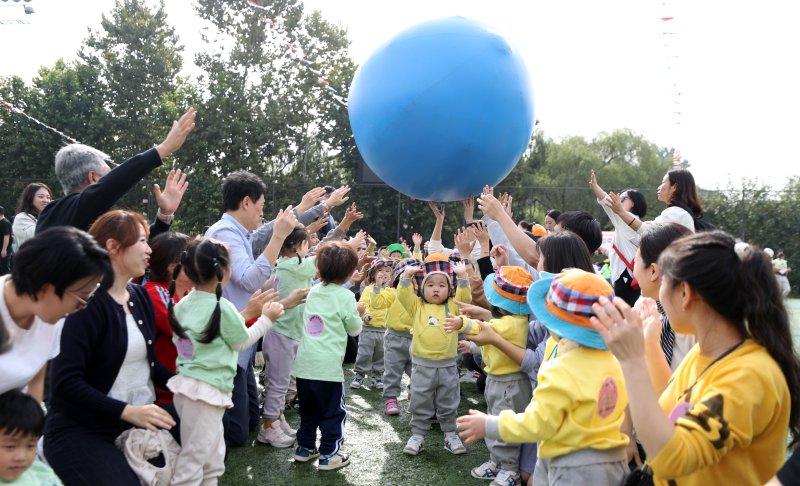 [서울=뉴시스] 김선웅 기자 = 13일 서울 송파여성축구장에서 열린 송파구 주최·송파구가정어린이집연합회 주관 '아기새들의 놀이한마당' 가을운동회에서 참여 어린이들과 학부모, 보육 교직원들이 공굴리기 경기를 하고 있다. 2023.10.13. mangusta@newsis.com