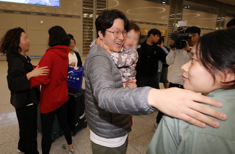 [인천공항=뉴시스] 조성우 기자 = 팔레스타인 무장 정파 하마스와 이스라엘 간 무력 충돌이 진행 중인 가운데 이스라엘 현지에 머물던 성지순례객 등 한국인 단기 체류자들이 11일 오전 인천국제공항 제2여객터미널을 통해 귀국했다. 한 시민이 이스라엘에서 돌아온 아이와 부인을 반갑게 맞이하고 있다. 2023.10.11. xconfind@newsis.com