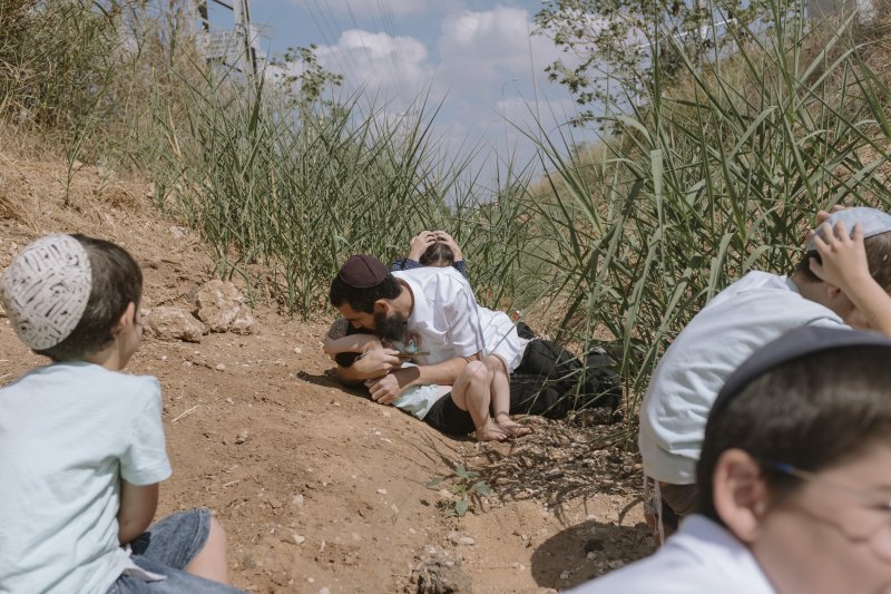 시난 13일 이스라엘 레호보트 주민들이 가자지구에서 발사된 로켓으로 공습경보가 울리자 몸을 피하는 모습. 사진=뉴시스