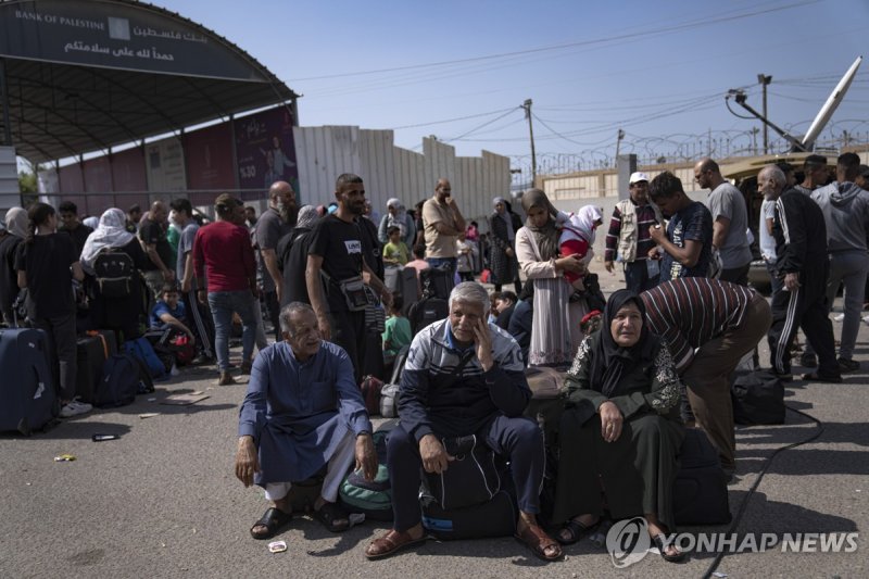 잠긴 라파 통행로 앞에 모여든 팔레스타인 주민 Palestinians wait to cross into Egypt at the Rafah border crossing in the Gaza Strip on Monday, Oct.16, 2023. (AP Photo/Fatima Shbair)