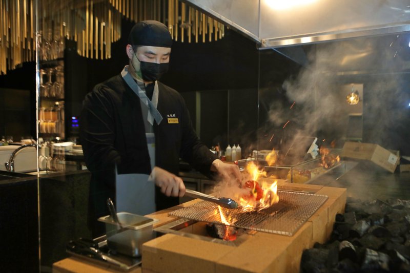 목탄장 셰프가 숯을 사용해 요리를 만들고있다.