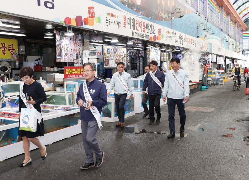 경북 포항시 죽도시장을 찾아 장을 보고 있는 DGB대구은행 임직원들.