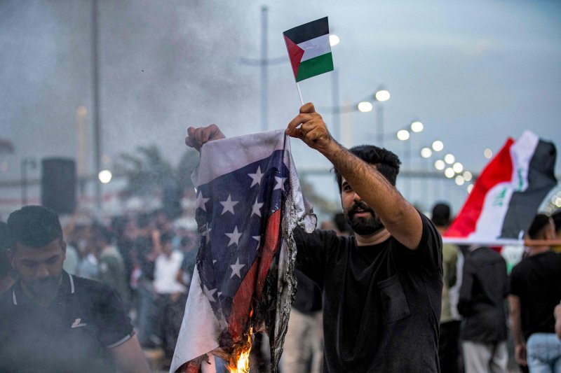 지난 20일(현지시간) 이라크 바스라에서 팔레스타인 국기를 든 시위대가 미국 성조기를 불태우고 있다.AFP연합뉴스