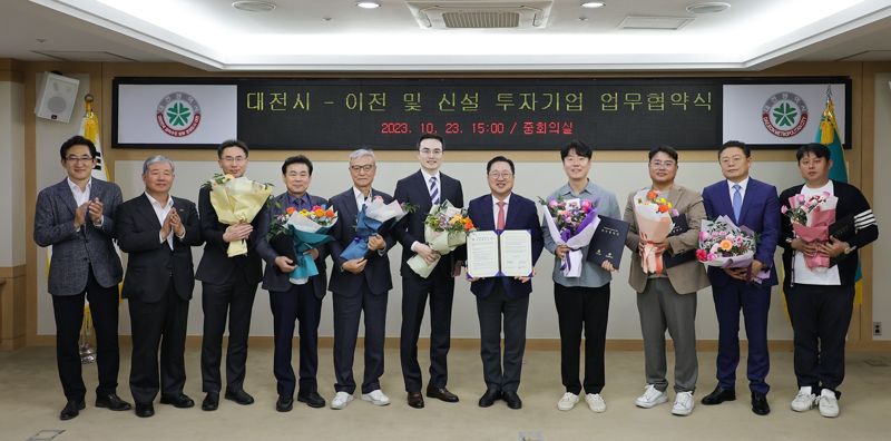 이장우 대전시장(오른쪽 5번째)이 23일 대전시청에서 국내 우량기업 8개사 대표들과 투자협약식을 가진 뒤 협약서를 들어보이고 있다.
