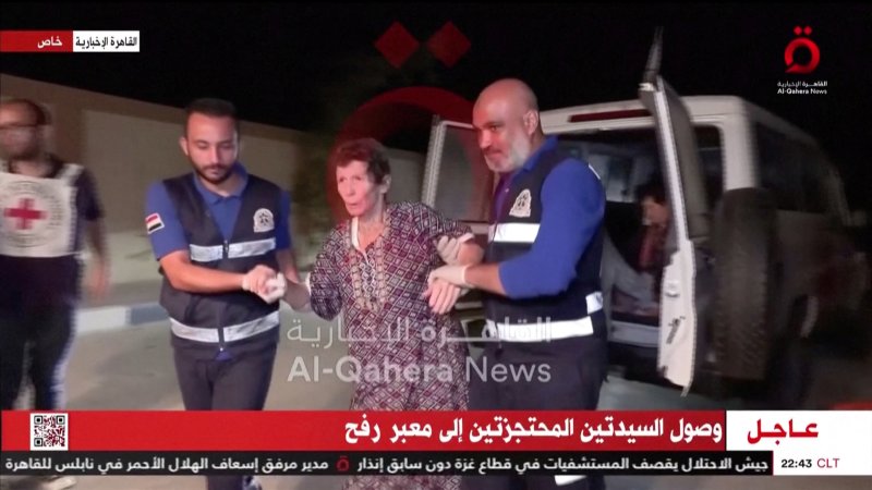 23일(현지시간) 팔레스타인 가자지구와 연결된 이집트 라파에서 하마스에게 납치되었던 85세 여성 요체브 리프쉬츠(가운데)가 구급대원들의 부축을 받고 있다.로이터뉴스1