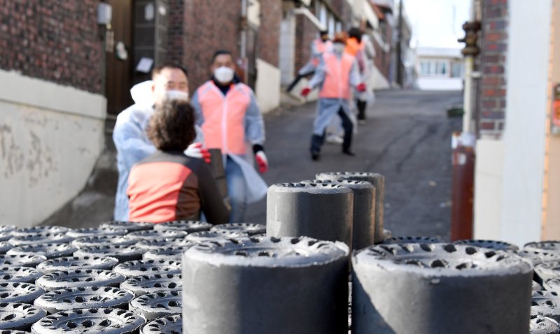 [광주=뉴시스] 류형근 기자 = 3일 오후 광주 북구 우산동 한 주택가 앞에서 우산동행정복지센터 통장단과 주민자치위, 직원 등이 '사랑의 연탄 나눔'을 하고 있다. 2020.12.03. hgryu77@newsis.com