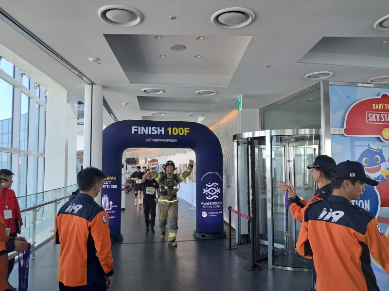 부산 해운대LCT 계단오르기 대회 참가자가 100층 결승선에 도착해 환호하고 있다. (부산소방재난본부 제공)