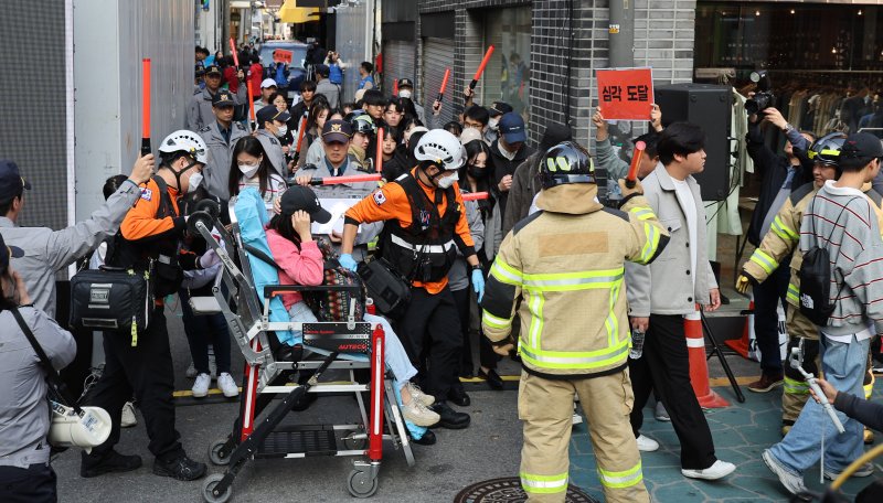 이태원 참사 1주기를 앞둔 25일 서울 광진구 건대맛의거리에서 시민들이 서울시가 새로 도입한 인파감지시스템 활용 유관기관 합동 다중운집 대응 훈련을 하고 있다. 뉴스1