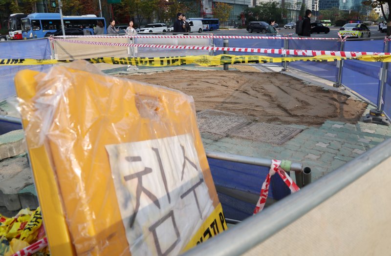 땅 거짐(싱크홀) 사고가 발생한 25일 오후 서울 영등포구 여의도동 IFC몰 앞 도로 내 횡단보도를 잇는 교통섬이 흙으로 메워져 있다. 영등포소방서와 영등포구청에 따르면 이날 오전 11시4분께 발생한 이번 사고로 깊이 4ｍ짜리 싱크홀이 생기면서 30대 남성 행인이 다리에 찰과상을 입고 병원에 이송됐으며, 땅 꺼짐 발생 원인 등을 조사할 예정이라고 밝혔다. 2023.10.25/뉴스1 ⓒ News1 김진환 기자