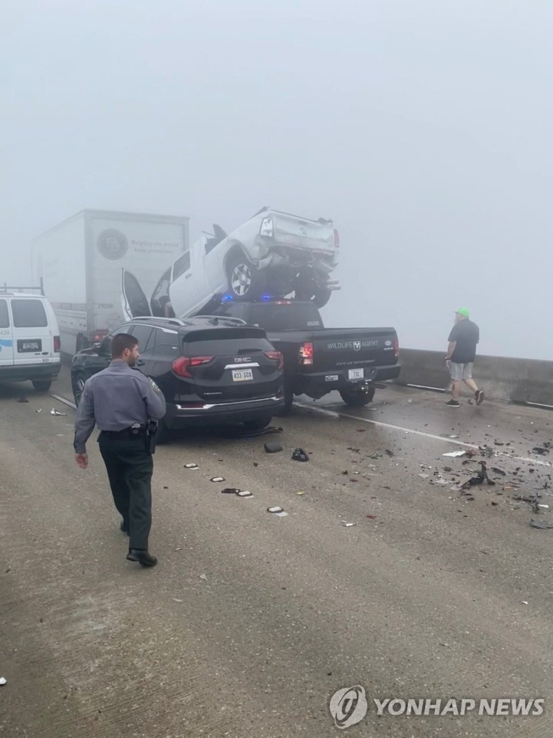 지난 23일(현지시간) 미 루이지애나 고속도로 연쇄 추돌사고 현장 찍은 소셜미디어 영상 People view the damage to trucks in a vehicle pile-up due to a "super fog" aggravated by marsh fires, along the Interstate 55 (I-55) highway in Louisiana, U.S., October 23, 2023 in this still image obtained from social media video. @NSGladiators via X