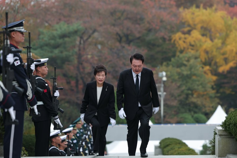 윤석열 대통령이 26일 국립서울현충원에서 열린 박정희 전 대통령 44주기 추도식을 마친 후 박근혜 전 대통령과 대화를 나누며 참배를 위해 묘소로 이동하고 있다. (대통령실 제공) /사진=뉴시스화상