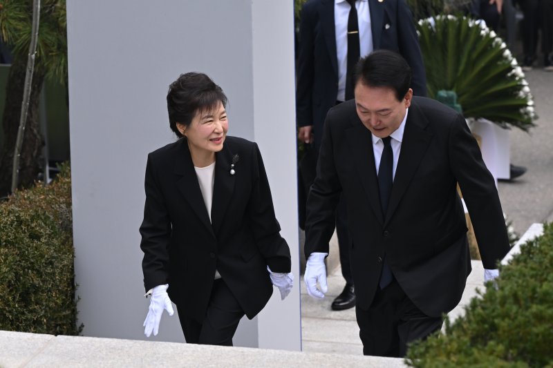 윤석열 대통령이 26일 서울 동작구 국립서울현충원에서 열린 박정희 전 대통령 서거 제44주기 추도식을 마친 후 박근혜 전 대통령과 함께 묘소로 향하며 대화하고 있다. 대통령실 제공