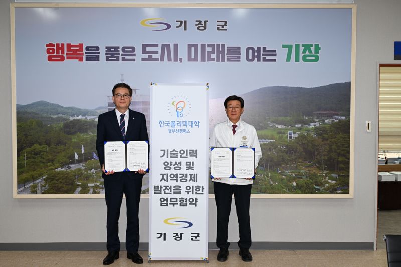 정종복 기장군수(오른쪽)와 황선구 한국폴리텍대학 동부산캠퍼스 학장이 27일 업무협약을 체결하고 기념촬영을 하고 있다. 기장군 제공