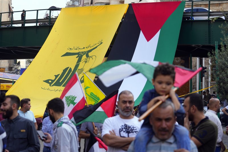 10월 27일(현지시간) 레바논 베이루트에서 시아파 무장정파 헤즈볼라의 지지자들이 다리에 헤즈볼라 깃발(왼쪽)과 팔레스타인 깃발을 나란히 게양한 가운데 팔레스타인 가자지구와 연대하는 행진을 하고 있다.AP연합뉴스